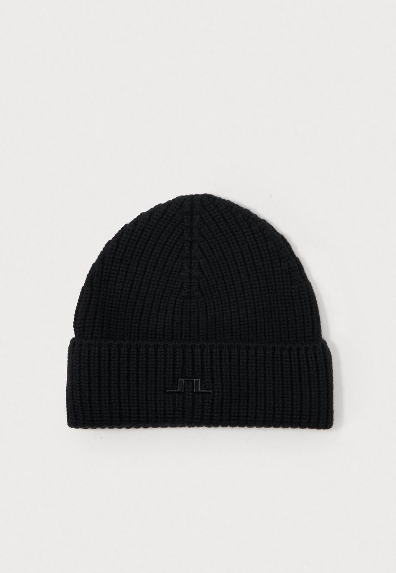 Gorro de punto negro con textura acanalada y puño plegado. Presenta un sutil acento de logo negro brillante en la parte frontal.