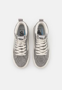 Zapatillas altas de ante gris con cordones blancos, detalles bordados y un interior acolchado. Presenta una etiqueta de logo en la lengüeta.