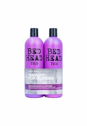 Kaksi violettia Bed Head TIGI -shampoopulloa ja hoitoainetta, joissa on etiketti "Therapy for Blondes" kemiallisesti käsitellyille hiuksille.