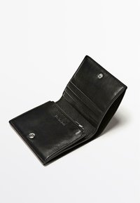 Sort læderpunge med trykknaplukning, flere kortlommer og en lynlåslomme til mønter. Glat tekstur og minimalistisk design.