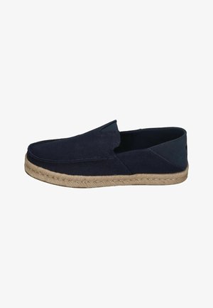 Marineblaue Leinen-Slipper mit Sohle aus Jute, ausgestattet mit einem flachen Profil, strukturiertem Obermaterial und elastischen Seitenpaneelen für einen bequemen Einstieg.