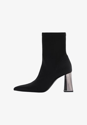 Čierne členkové čižmy z elastického materiálu s špicatou špičkou a lesklým, geometrickým blokovým podpätkom. Hladký povrch s minimálnymi švami.