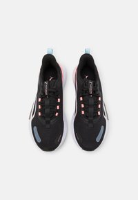 Svarta träningsskor med mesh-övre del, rosa detaljer och vit sula. Har snören, en dragflik och en rund blå logotyp på sidan.