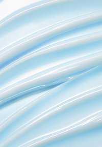 Vaaleansininen kerma levitetty sujuvin, kaarevin viivoihin, joissa on kiiltävä pinta ja hienovaraiset sävyn ja rakenteen vaihtelut.