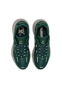 Gröna nät- och mockaskor med en kraftig vit sula, som har reflekterande detaljer, texturerade snören och varumärkeslogotyp på tungan.