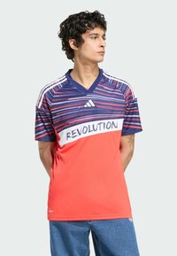 Rood en marineblauwe gestreepte sporttrui met een v-hals, "REVOLUTION" grafiek over de borst en witte driekleurige accenten op de mouwen.