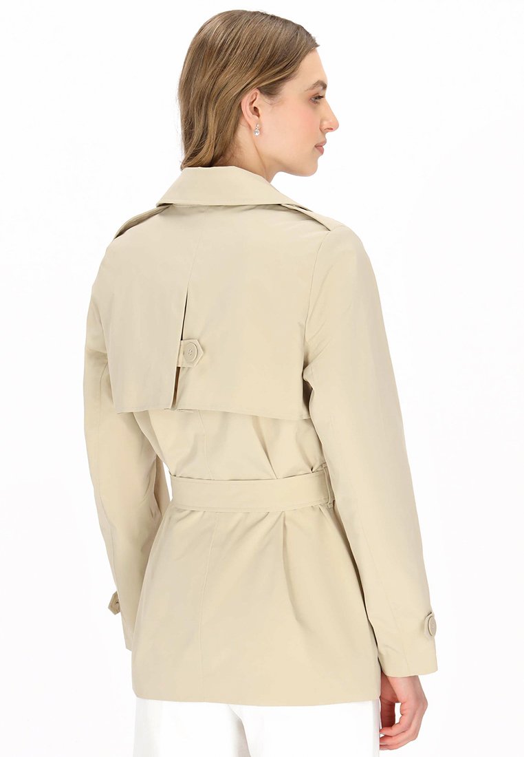Beige trench coat with a belted waist, a notched collar, and a back pleat detail. Smooth, lightweight fabric with button accents.