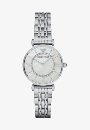 Reloj de acero inoxidable plateado con una esfera redonda de madreperla, números romanos y un círculo adornado con cristales. Diseño de pulsera vinculada.
