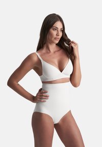 Set di lingerie bianca composto da un reggiseno triangolare senza ferretti e una mutanda alta in vita. Tessuto liscio con design senza cuciture e hardware minimo.
