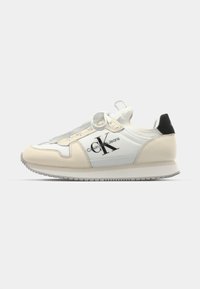 Adidașii Calvin Klein Jeans în nuanțe de bej deschis și alb din piele, cu accente negre, având vârful rotund și un sistem de șireturi pentru o fixare sigură.