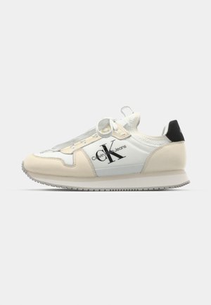 Adidașii Calvin Klein Jeans în nuanțe de bej deschis și alb din piele, cu accente negre, având vârful rotund și un sistem de șireturi pentru o fixare sigură.