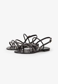 Zwarte platte sandalen met meerdere samengevlochten banden met metalen accenten, een gladde matte afwerking en een verstelbare enkelgesp.