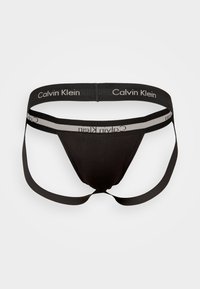 Schwarze Stringunterwäsche mit elastischem Bund, der mit "Calvin Klein"-Branding versehen ist. Hergestellt aus glattem Stoff mit minimalistischem Schnitt.