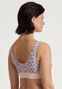 Bralette met bloemenpatroon in zachtroze met brede bandjes en een gladde textuur. Heeft een effen roze band aan de onderkant en een lage scoop rugontwerp.