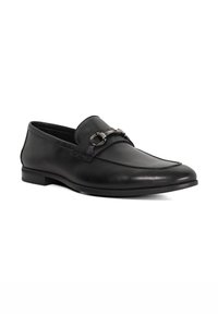Black leather loafers featuring a smooth texture, slip-on design, and a metallic chain accent across the instep. Low heel.