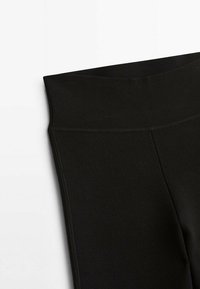 Czarne legginsy z szerokim, elastycznym pasem, wykonane z gładkiego, rozciągliwego materiału. Projekt charakteryzuje się dopasowanym krojem i brakiem widocznych szwów.