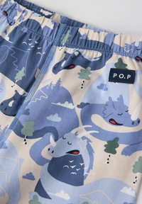 Blauwe en crèmekleurige shorts met een patroon van speelse drakontwerpen, een elastische tailleband en een gestikt label met "P.O.P." branding.