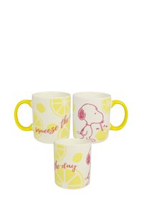 Ceramic mugs with yellow handles, featuring lemon patterns and pink illustrations of a dog sipping lemon juice. Text includes "squeeze the day."