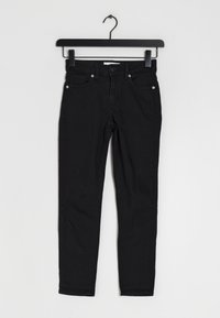Jeans ajustados negros de algodón con una textura suave. Presenta cinco bolsillos, trabillas para cinturón y detalles de botones metálicos.