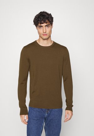 Brown long-sleeve sweater with a round neckline and ribbed cuffs, worn with blue jeans. Fabric has a smooth texture and slight stretch.