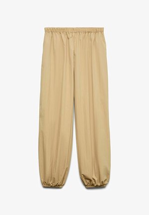 Pantalon beige ample avec taille élastique et poignets élastiques froncés, en tissu léger.