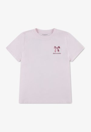 Hellrosa kurzärmeliges Kinder-T-Shirt mit einer kleinen dunkelrosa Schleife und dem Schriftzug „Abercrombie“ auf der linken Brust.