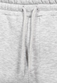 Světlé šedé tepláky s texturovanou tkaninou, elastickým pasem, tkaničkou s vzorem rybí kosti a bočními kapsami.