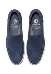 Scarpe slip-on in suede blu navy con una texture liscia, cuciture a contrasto e suola in gomma bianca. Presentano una soletta con marchio e un design semplice.