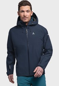 Marineblaues wasserdichtes Jackett mit Kapuze, Frontreißverschluss und verstellbaren Kordeln. Enthält ein Logo auf der Brust und Reißverschlusstaschen.