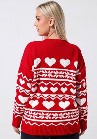 Czerwony sweter z dzianiny z białym sercem i wzorami geometrycznymi, z prążkowanymi mankietami i brzegiem. Luźny, casualowy krój z okrągłym dekoltem.