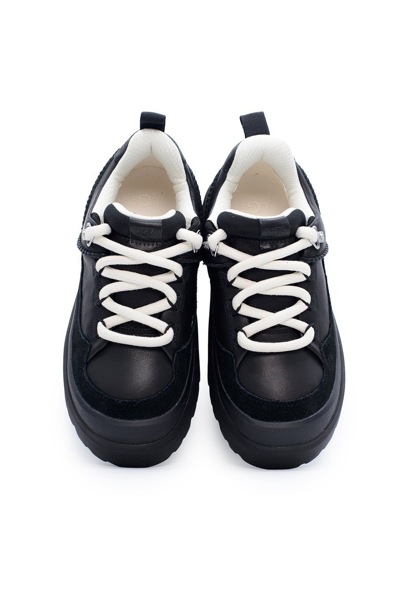 Zwarte sneakers met een bovenwerk van leer en suède, witte veters, een gevoerde kraag en een chunky zool. Voorzien van een logo op de tong en reflecterende accenten.