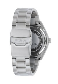 Montre en acier inoxydable avec un bracelet à maillons et une boucle. Présente un boîtier rond en argent et une boucle texturée. Résistante à l'eau.