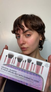 Crystal Quartz 12-delars borstsätt med rosa handtag och syntetiska borststrån. Inkluderar ett genomskinligt kosmetikfodral med texturerad design.