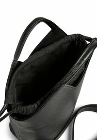 Juodas odinis kibirėlis su raišteliu ir dviem rankenomis, parodantis atvirą vidų ir lygią tekstūrą išorėje.