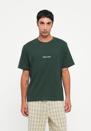 Tricou din bumbac verde închis, cu guler rotund și mâneci scurte; prezintă textul "Original Studio" brodat alb pe piept.