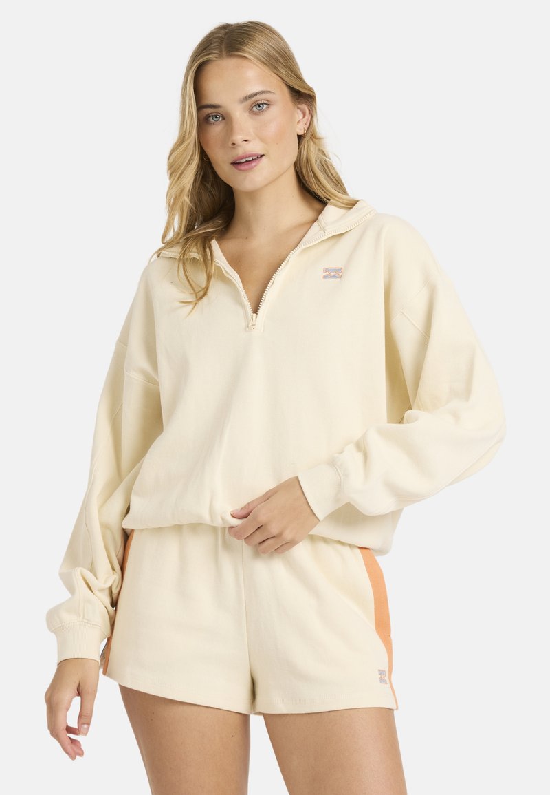 Πουλόβερ από ελαφρύ βαμβάκι σε κρεμ απόχρωση με γιακά και φερμουάρ έως το ένα τέταρτο, διακριτικό λογότυπο και χαλαρή εφαρμογή με μακριά μανίκια. Συνδυάζεται με σορτς σε ίδιο χρώμα.