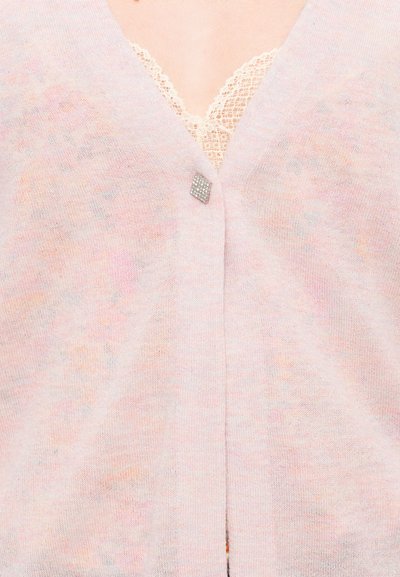 Hellrosa Strickjacke mit weicher Textur, die ein dezentes, mehrfarbiges Muster aufweist. Mit einem diamantenähnlichen Knopf in der Mitte geschlossen.