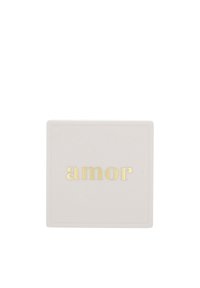 Weiße quadratische Fliese mit dem Wort "amor" in goldenen Kleinbuchstaben, das zentriert darauf steht.