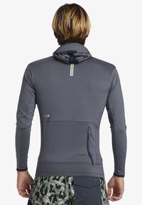 Grå långärmad hoodie med en dragkedjeficka och textil struktur, med rak fåll och en minimalistisk design.