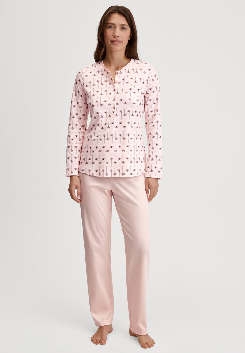 Pyjama set met een lang mouwtop met een roze bloemenprint op een lichtroze achtergrond, gecombineerd met effen roze, zachte stofbroeken.