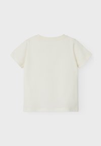 Short-sleeve, cream-colored T-shirt made of soft cotton. Features a round neckline and simple design without additional embellishments.