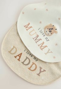 To bomuldsbind, den ene cremefarvet med beige stjerner og en broderet giraff, den anden beige med trykt tekst "Jeg elsker min FAR" og "Jeg elsker min MOR."