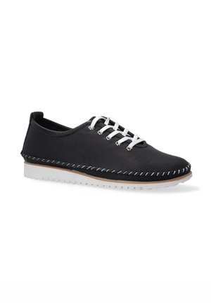 Zwarte leren schoen met witte veters, met een gestikt ontwerp langs de zool en een gestructureerde bovenkant. Witte rubberen zool.