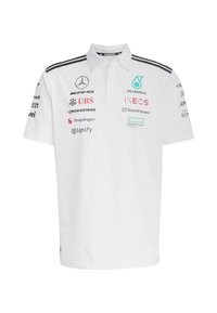 White polo shirt with short sleeves, featuring logos in black, green, and red. It has a classic collar and three black stripes on shoulders.