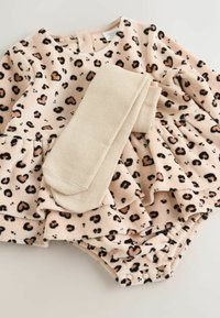 Leopard print romper in soft beige fabric with ruffled skirt. Includes matching beige tights. Snap closure at the bottom for easy dressing.