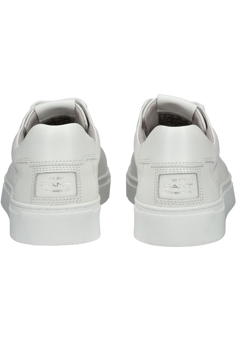 Vita lädersneakers med en slät yta, vadderad krage och strukturerad gummisula. Har en liten logopatch på hälen.