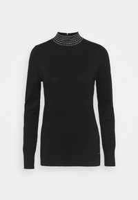 Svart tröja med hög krage som har silver-nitade detaljer. Långa ärmar, åtsittande design och en jämn textur. Klassiskt stickat material.