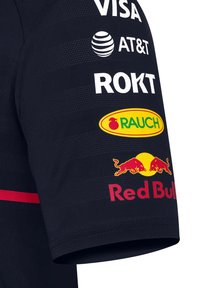 Navy jersey z nadrukowanymi logo w białym i kolorowym. Znane marki to Red Bull i RAUCH. Lekki, teksturowany materiał z krótkimi rękawami.
