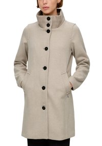 Beige wollenblend jas met een hoge geribbelde kraag, zwarte knopen, zijzakken en een losse pasvorm, met een gestructureerd weefpatroon.