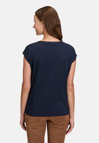 Navy blue short-sleeve t-shirt with a round neckline accented by a subtle shine. Soft, stretchy fabric. Features a relaxed fit.